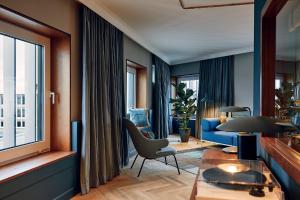 a living room with a blue couch and a table at Villa Viva - ein Haus das Brunnen baut in Hamburg