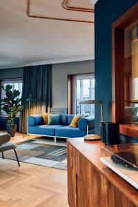 a living room with a blue couch in a room at Villa Viva - ein Haus das Brunnen baut in Hamburg