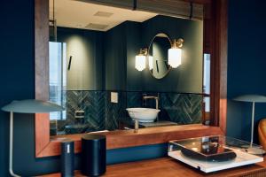 a bathroom with a sink and a mirror at Villa Viva - ein Haus das Brunnen baut in Hamburg