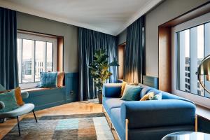 a living room with a blue couch and windows at Villa Viva - ein Haus das Brunnen baut in Hamburg