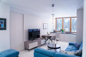 a living room with a blue couch and a table at Apartments Letná, AC & garage 89m2 and 44m2 in Košice