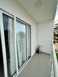 科韋尼亞斯的住宿－Acogedor apartamento cerca al Mar，白色房子,阳台上设有大窗户