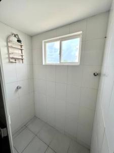 科韋尼亞斯的住宿－Acogedor apartamento cerca al Mar，浴室设有白色瓷砖淋浴和窗户