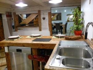 een keuken met een wastafel en een aanrecht met wijnglazen bij le marmoton in Thônes