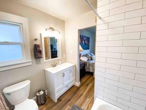 uma casa de banho com um WC, um lavatório e um espelho. em Adorable Guest Suite Central/trendy neighborhood em Colorado Springs