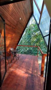a wooden deck with a table and a glass roof at Pozas y Cataratas La Presa in Ángeles