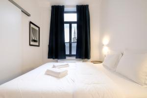 1 dormitorio con 1 cama blanca grande y ventana en The Duke flats - 1 bedroom apartments Grand Place en Bruselas