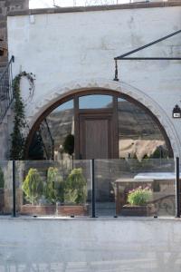 un arco con piante in vaso di fronte a un edificio di Vigor Cappadocia - Special Class a Üçhisar