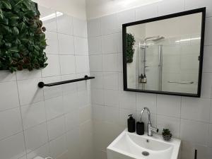 een witte badkamer met een wastafel en een spiegel bij David Frishman Residence - Sea view penthouse in Tel Aviv