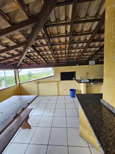 um quarto vazio com piso em azulejo e tectos em madeira em Pousada Recanto das Ondas em Garopaba