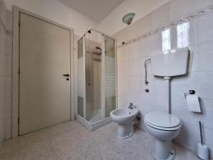y baño blanco con aseo y ducha. en Appartamento La casa dei nonni, en Malnate