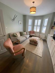 a living room with a couch and a chair at Stunning 4BD House wLarge Garden - Finsbury Park! in London