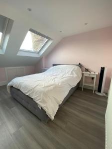 a bedroom with a bed and a skylight at Stunning 4BD House wLarge Garden - Finsbury Park! in London