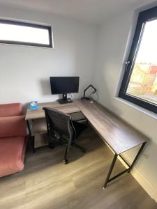 a desk with a computer and a chair in a room at Stunning 4BD House wLarge Garden - Finsbury Park! in London