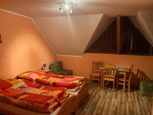 2 łóżka w pokoju ze stołem i krzesłami w obiekcie Penzión Serafín w Rużomberku
