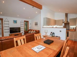 a kitchen and living room with a wooden dining table at 2 Stonerush Valley in Looe
