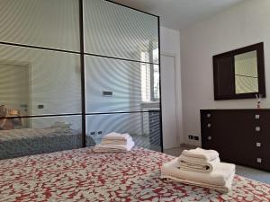 1 dormitorio con 1 cama grande y toallas. en Appartamento La casa dei nonni, en Malnate