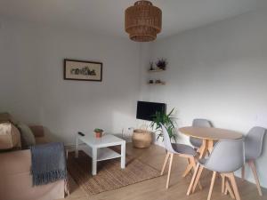 ein Wohnzimmer mit einem Tisch, Stühlen und einem Sofa in der Unterkunft Apartamento en Mogro. in Mogro