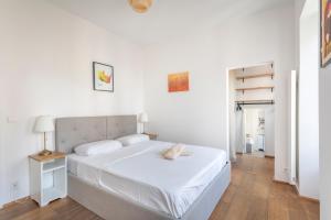 a white bedroom with a white bed and a table at Calme, soleil, plage - Catalans in Marseille