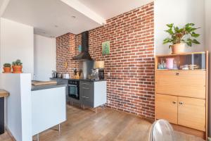 a kitchen with a brick wall and a counter top at Calme, soleil, plage - Catalans in Marseille