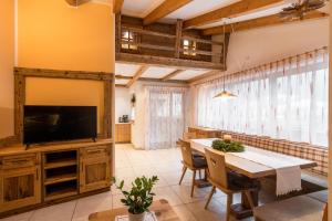 a dining room with a television and a table and chairs at Haus Alpenjuval in Fundres