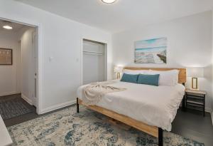 a white bedroom with a large bed with blue pillows at Quaint 1BD/1BA Bungalow- Venice Beach in Los Angeles
