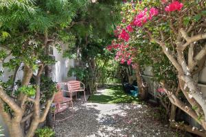 a garden with a bench and pink flowers and trees at Quaint 1BD/1BA Bungalow- Venice Beach in Los Angeles