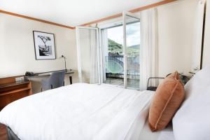Schlafzimmer mit einem Bett, einem Schreibtisch und einem Fenster in der Unterkunft Hotel Engel Business & Lifestyle in Liestal