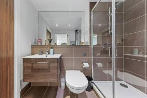 a bathroom with a toilet and a sink and a shower at Brand new apartment 20 mins from London Waterloo BP34 in London
