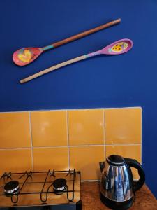 a stove top with a tea pot and utensils on the wall at Pousada Estrela Cordel in Fernando de Noronha