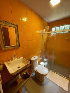 a bathroom with a toilet and a sink and a shower at Pousada Estrela Cordel in Fernando de Noronha