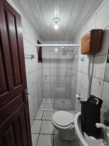 uma casa de banho com um WC e um chuveiro em Pousada Recanto das Ondas em Garopaba