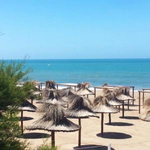Casa a estrenar 450 metros de la playa في قويقوين: مجموعة من مظلات القش على الشاطئ