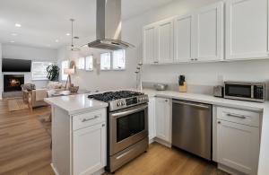a kitchen with white cabinets and a stove top oven at Exclusive 2BD 3BA with Balcony Venice Beach in Los Angeles