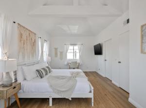 a white bedroom with a white bed and a television at Exclusive 2BD 3BA with Balcony Venice Beach in Los Angeles