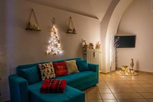 een blauwe bank in een woonkamer met een kerstboom bij Casa Della Nonna in Manfredonia