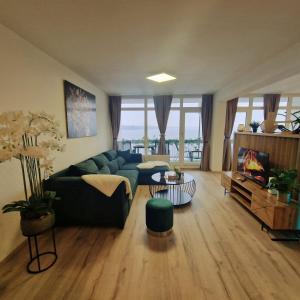 a living room with a green couch and a tv at Ferienwohnung mit Meerblick in Bad Zwischenahn in Bad Zwischenahn