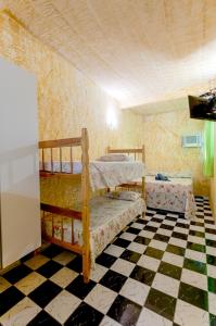1 dormitorio con 2 literas y suelo a cuadros en Pousada John John, en Guarujá