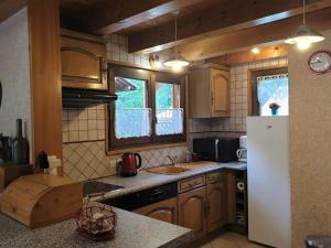 a kitchen with wooden cabinets and a white refrigerator at Chalet Morzine, 3 pièces, 5 personnes - FR-1-754-77 in Morzine