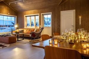 uma sala de estar com uma mesa e um sofá em Villa Budor 1.5 time fra Oslo em Nordset