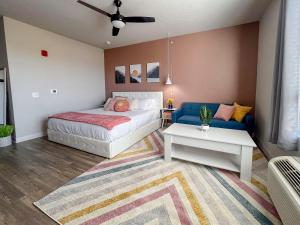 a bedroom with a bed and a couch at Boho-Luxe Studio - Pink Accents & Mountain Calm in Boise +24 photos