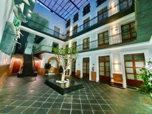 a building with a tree in the middle of a courtyard at Hotel Puebla Plaza in Puebla