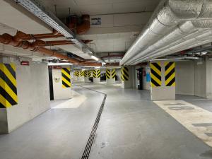 an empty parking garage with yellow and black stripes on the walls at Belnea Nadmotławie - Comfy Apartments in Gdańsk