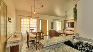 a kitchen and living room with a table and chairs at #018 Casa 2 minutos a pé da Praia de Palmas in Governador Celso Ramos