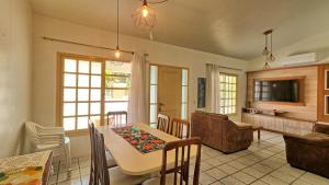 a kitchen and living room with a table and chairs at #018 Casa 2 minutos a pé da Praia de Palmas in Governador Celso Ramos