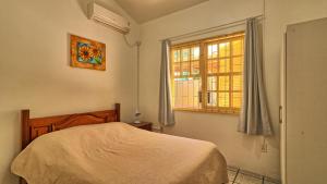 a bedroom with a bed and a window at #018 Casa 2 minutos a pé da Praia de Palmas in Governador Celso Ramos