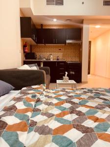 uma cama grande numa sala de estar com uma cozinha em Cozy and Spacious Studio no Dubai