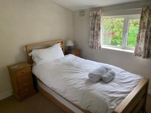 a bedroom with a bed with two towels on it at Garbutt Cottage in Langthwaite