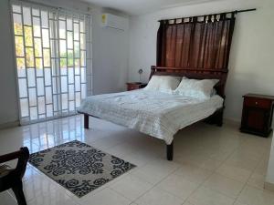 - une chambre avec un lit doté d'une tête de lit en bois et de fenêtres dans l'établissement Casa hostal Rochymar, 