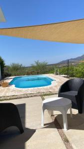 a swimming pool with a bench and a table at QHAWANA CABAÑAS & SUITES in La Rioja
